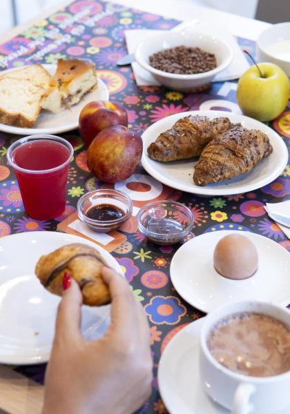 Herzhaftes Frühstück mit Croissants, Eiern, Obst und Getränken.