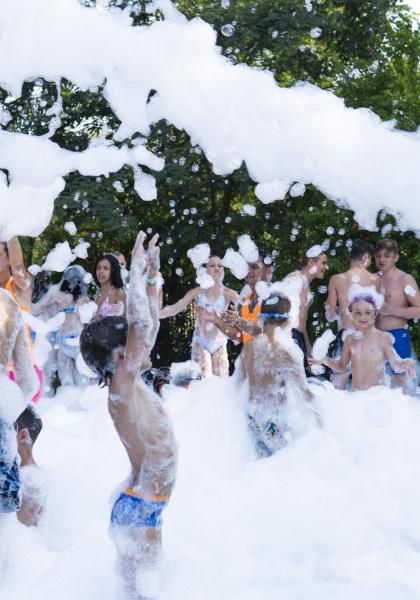 Menschen genießen eine Schaumparty im Freien.