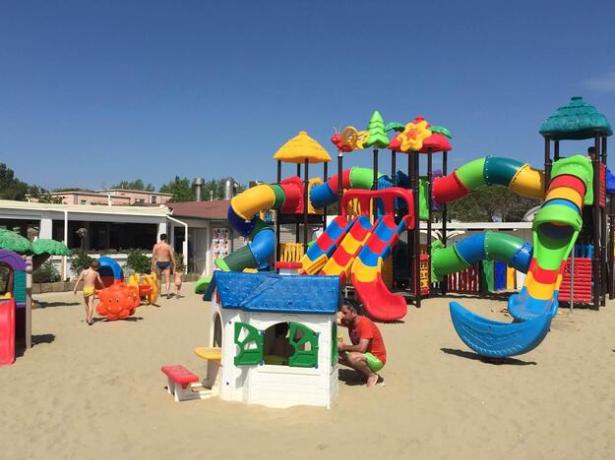 Bunter Spielplatz am Strand mit Rutschen und Kinderspielen.