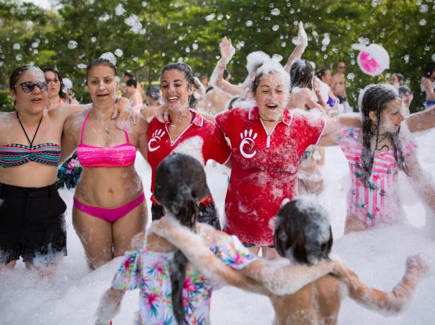 Des gens s'amusent à une fête de mousse en plein air.