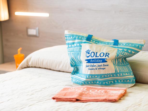 Sac et serviette sur lit à l'hôtel Color Holiday.
