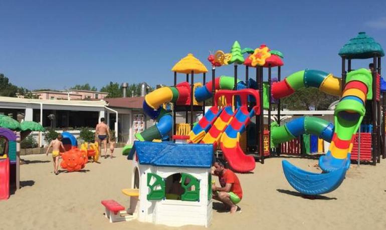 Colorful playground on the beach with slides and children's games.