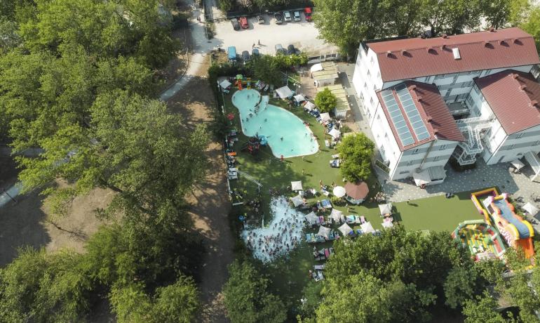 Vue aérienne d'une piscine bondée à côté d'un bâtiment.