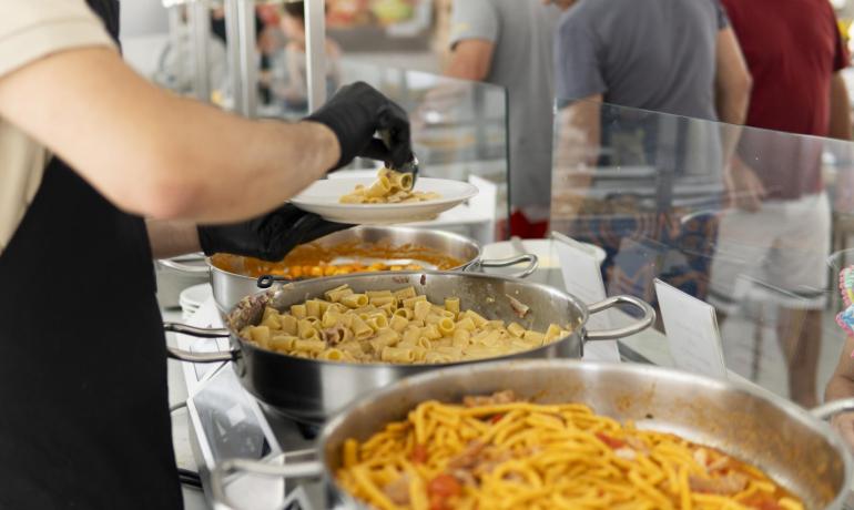 Servizio buffet di pasta con vari condimenti.