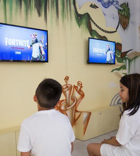 Sala giochi con supereroi, TV e arredi colorati per bambini.