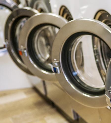 Row of industrial washing machines, order and cleanliness in a modern setting.