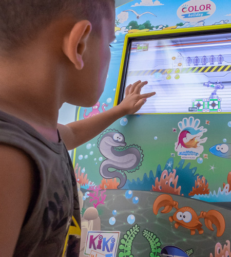 Bambina e donna giocano insieme su un tappeto colorato con giocattoli educativi.