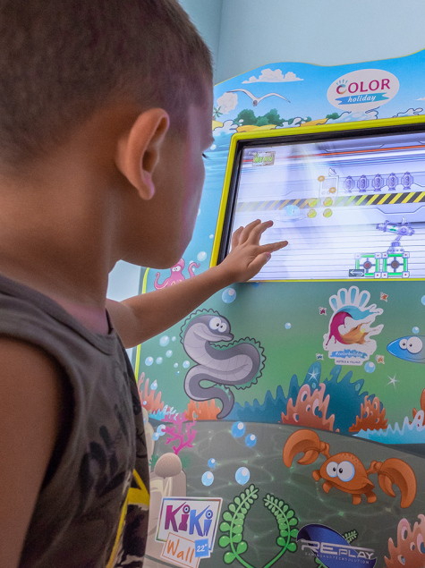 Bambina e donna giocano insieme su un tappeto colorato con giocattoli educativi.