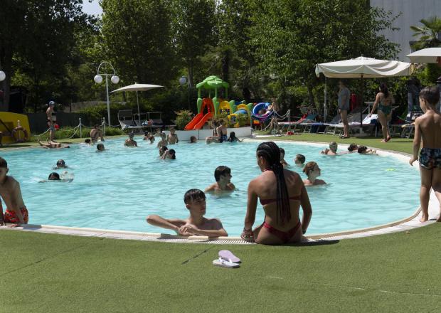 Piscina all'aperto con bambini che giocano e si divertono.